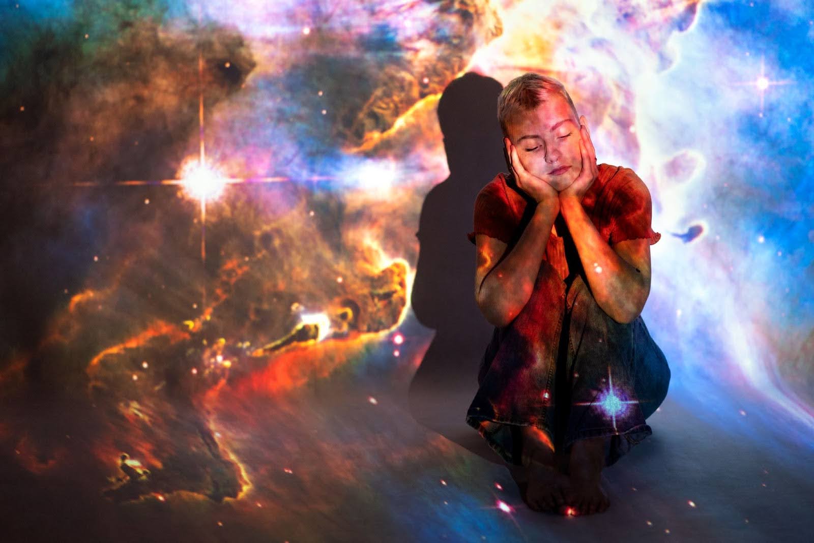 Person sitting with closed eyes in a colourful cosmic nebula, symbolising imagination, creativity and the expressive energy of the fifth house in Vedic astrology