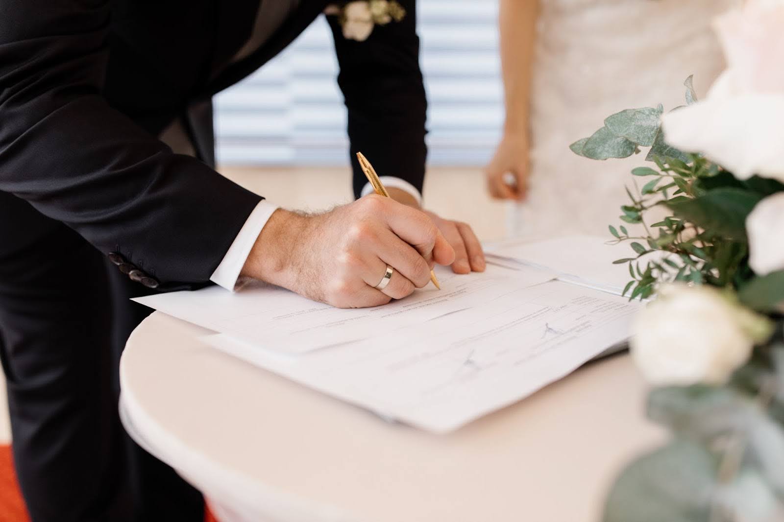 Groom signing a marriage document at a wedding table, symbolising the seventh house themes of partnership, commitment and formal agreements in Vedic astrology.